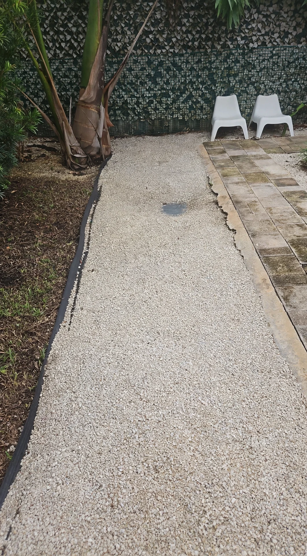 Finished gravel drainage path with installed grate